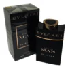 Frasco de perfume Bvlgari Man In Black Eau De Parfum 100ml, com líquido âmbar escuro e tampa preta, em fundo escuro com reflexos.